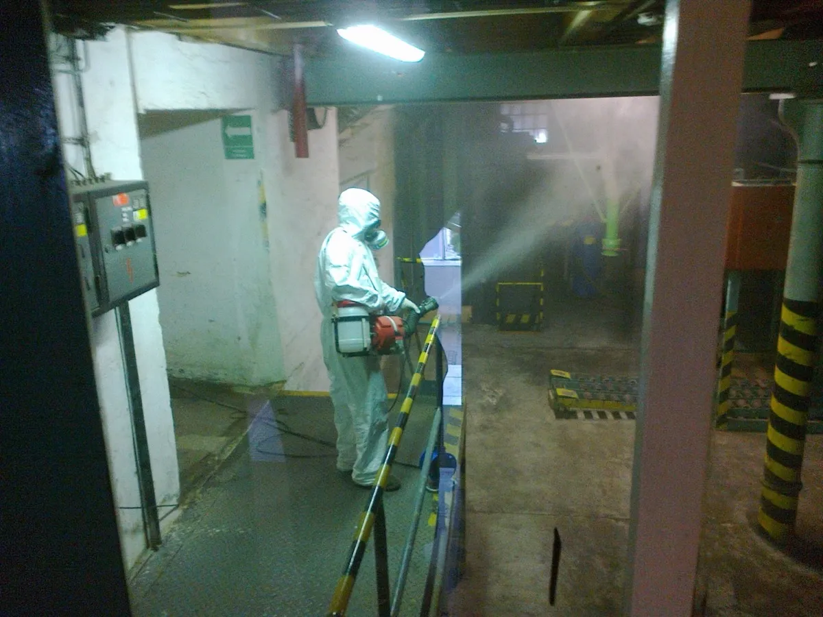 Ohnisková dezinfekce — technik v ochranném obleku